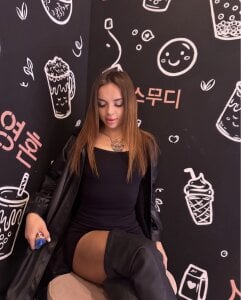 MeantWeek Black outfit, sitting with blue background . fénykép